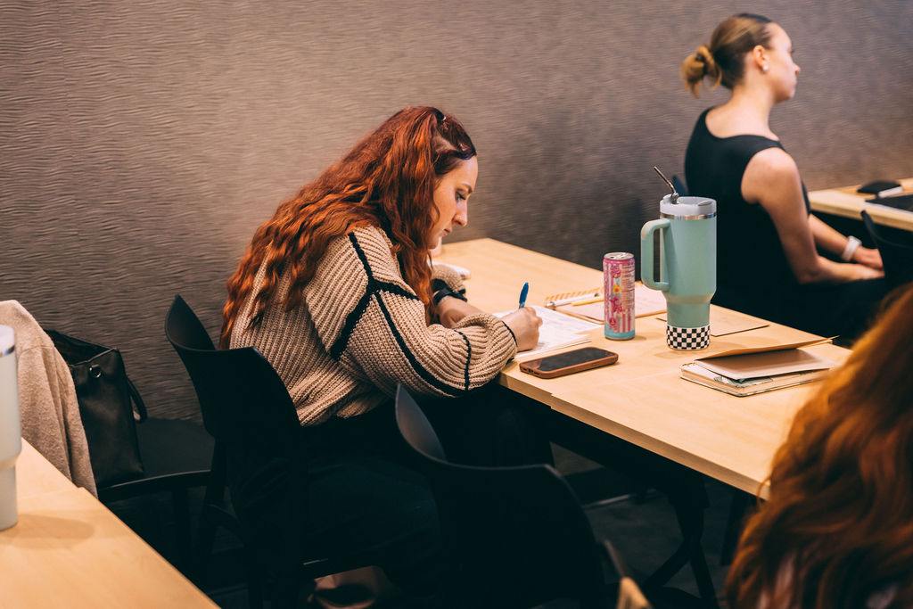 A woman writing notes at the StudioSpace meeting table